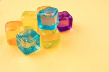 Sarı bir arka plan üzerinde renkli buz küpleri içinde sahte