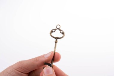 Beyaz arka planda eski moda metal bir anahtar tutan el.
