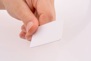 Beyaz arka planda bir kağıt parçasını tutan el.