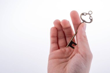 Beyaz arka planda eski moda metal bir anahtar tutan el.