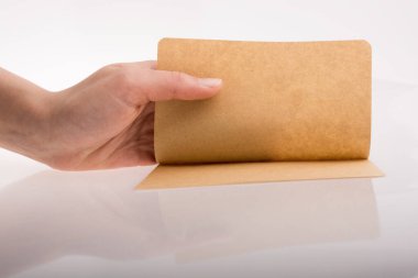 Beyaz arka planda bir sayfa kağıt tutarken