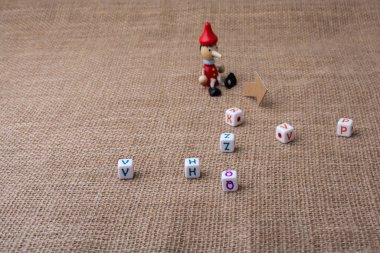 Pinokyo bebek üzerine yağlıboya harf küpleri yanında oturan