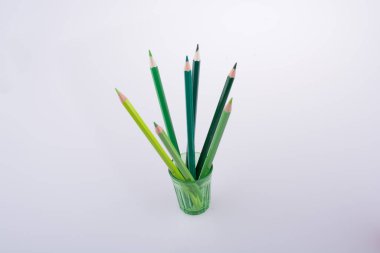 Beyaz bir arka plan üzerinde renkli bir cam renkli kalemler