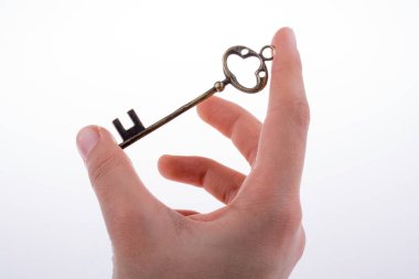 Beyaz arka planda eski moda metal bir anahtar tutan el.
