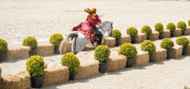 Osmanlı atlısı etnik kıyafetleriyle atına biniyor.