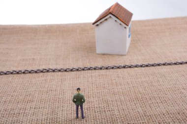 Adam heykelcik ve bir tuval zinciri hatta ötesinde bir Model ev ayakta