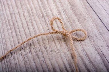 Açık renk arka plan üzerinde düğüm olarak bağlı iş parçacığı