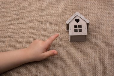 Çocuk tuvaldeki model evi işaret ediyor.