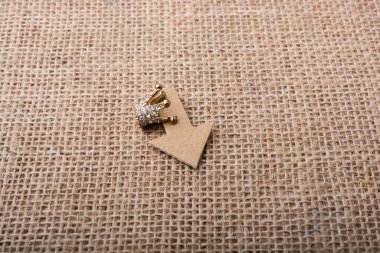 Mini taç ve tuval üzerinde kağıt ok.