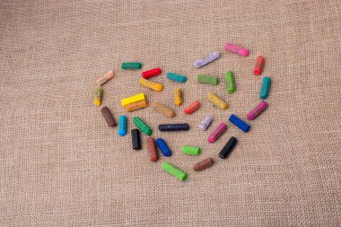 Renkli boya kalemleri tuval üzerinde bir kalp şekli oluşturur