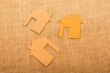 Tuvalin arka planında kağıttan yapılmış küçük bir ev şekli.