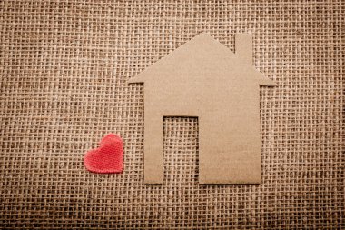 Kalp şekli bir tuval arka plan ile kağıt ev yanında