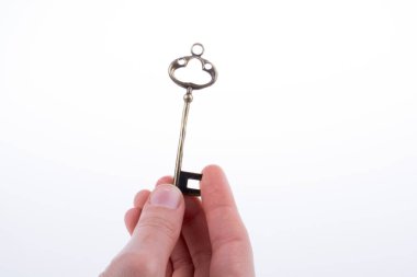 Beyaz arka planda eski moda metal bir anahtar tutan el.