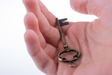 Beyaz arka planda eski moda metal bir anahtar tutan el.