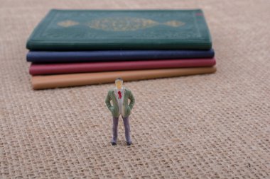 Adam heykelcik ayakta tuval üzerine küçük kitap yanında