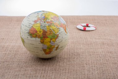 Tuvalin arka planına yerleştirilmiş bir kürenin yanında can yelekleri