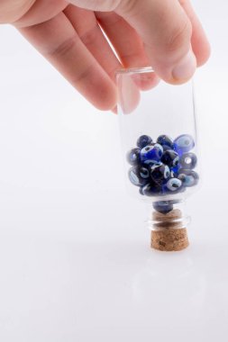 Küçük cam şişe mavi nazar boncuk ile el
