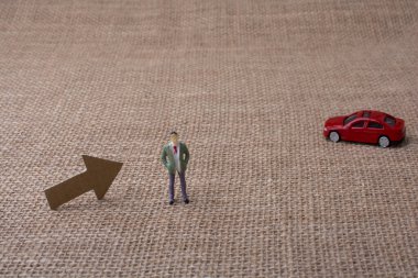 Ok ve bir adam heykelcik ve kırmızı oyuncak araba bir tuval arka plan