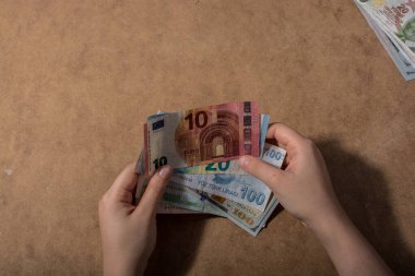 El ele tutuşan Amerikan doları banknotları ahşap arka planda izole edilmiş.