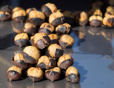 Sıcak ateşte kızartılmış organik kahverengi kestaneler.