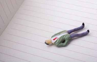 Beyaz bir kağıt üzerinde dinlenen erkek heykeli