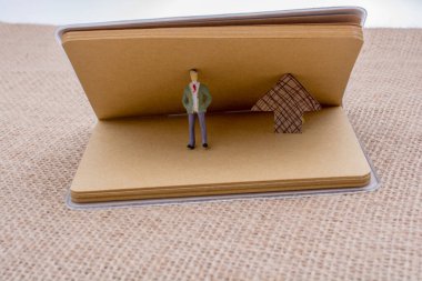 Heykelcik ve tuval üzerine bir defter kağıt ok