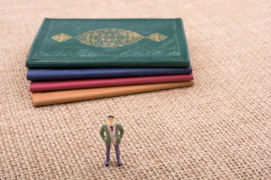 Adam heykelcik ayakta tuval üzerine küçük kitap yanında