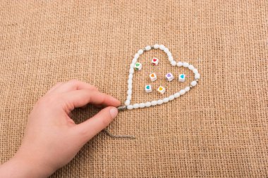 Elinde tuval üzerinde kalp şeklinde bir nesne