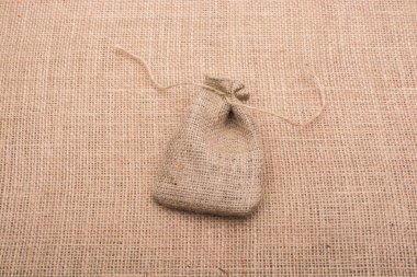 Tuvalin arka planında ketenden yapılmış boş küçük çuval.