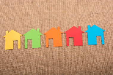 Tuvalin arka planında renkli kağıttan kesilmiş küçük bir ev şekli