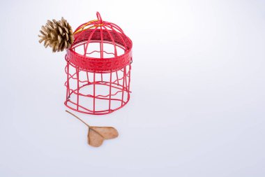 Çam kozalağı bağlı kuş kafesi ve bir duymak için şekli kesme yaprak