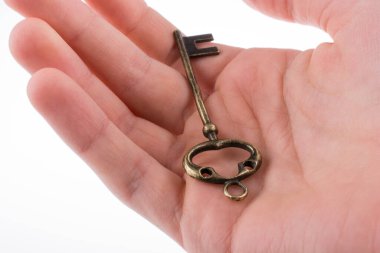 Beyaz arka planda eski moda metal bir anahtar tutan el.