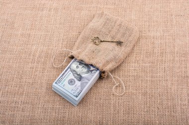 Retro anahtar ve bir çuval dolusu Amerikan doları tuvalde.