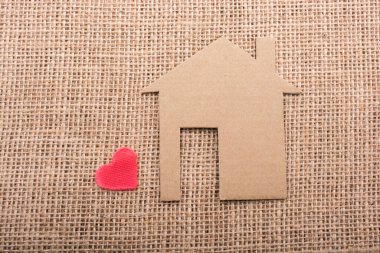 Kalp şekli bir tuval arka plan ile kağıt ev yanında