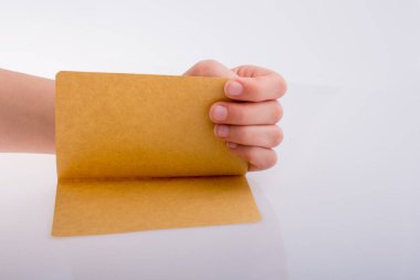 Beyaz arka planda bir sayfa kağıt tutarken