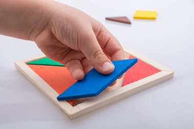 Tangram bulmacasının kayıp parçasını tutan el.