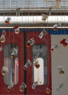 İplere asılı çiçekli bitkisel çay şişeleri