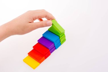 Beyaz arkaplanda renkli domino taşıyla el oyunu