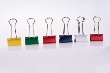 Beyaz arkaplanda renkli ataçlar