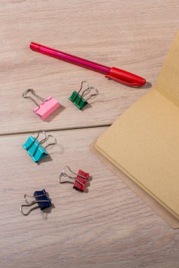 Kahverengi renk defter, kalem ve kağıt klipleri ahşap doku