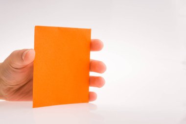 Beyaz bir arka plan üzerinde turuncu renkli dikdörtgen kağıt tutan el