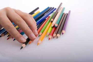 Beyaz arkaplanda el ele tutuşan renkli kalemler