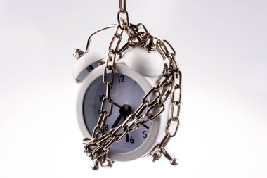 White color alarm clock in chain on a white background clipart