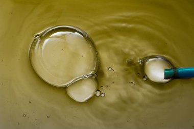 Suyun üzerindeki renkli su kabarcıkları çekyat alanı gibi.