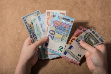 El ele tutuşan Amerikan doları banknotları ahşap arka planda izole edilmiş.