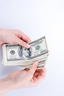 İnsan eli, Amerikan doları banknotunu beyaza izole edilmiş olarak tutuyor.