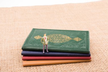 Adam heykelcik ayakta tuval üzerine küçük kitaplar