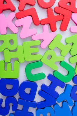 Beyaz arkaplana rastgele dağılmış renkli harf blokları