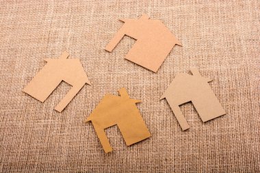 Tuvalin arka planında kağıttan yapılmış küçük bir ev şekli.