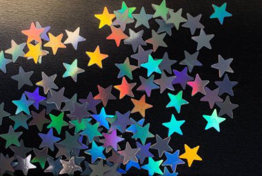 Koyu renkli konfeti yıldız karanlık bir arka plan üzerinde